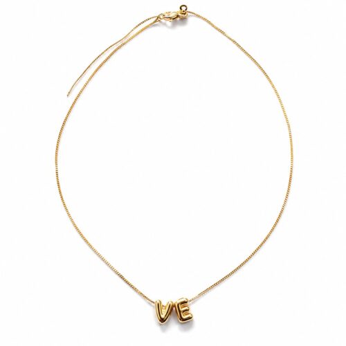 Minimalist gold VE necklace worn by a model. Inspired by Venezuela and created to represent hope, resilience, and unity while supporting humanitarian efforts.